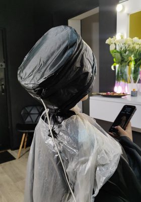 Клієнтка під час етапу витримки лікувальної маски для волосся